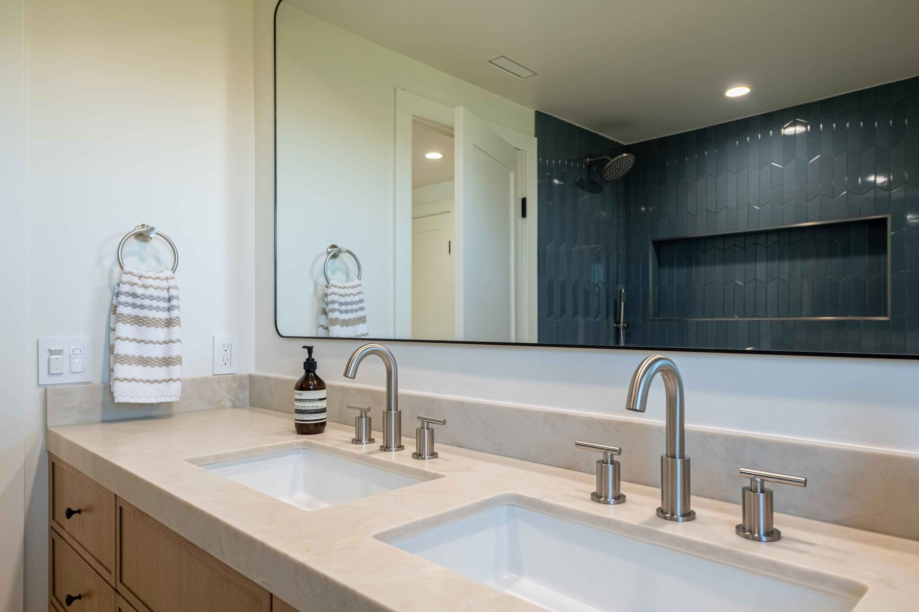 Vanity with brushed nickel faucets and stone backsplash